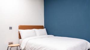 a bedroom with a white bed and a blue wall at Student Only Studio in Central Loughborough in Loughborough +20 photos