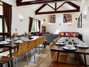 a dining room with tables and chairs and a couch at Howgills Barn in Sedbergh