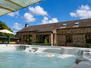a hot tub in front of a house at Howgills Barn in Sedbergh