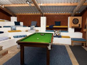 a billiard room with a pool table and couches at Howgills Barn in Sedbergh
