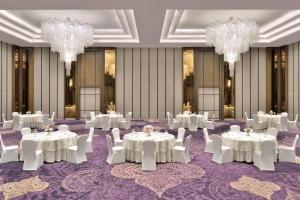 a ballroom with white tables and chairs and chandeliers at Courtyard by Marriott Siliguri in Siliguri +85 photos