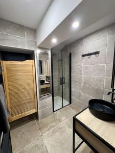 a bathroom with a glass shower and a sink at Le Gustave - Proche ville in La Rochelle +13 photos