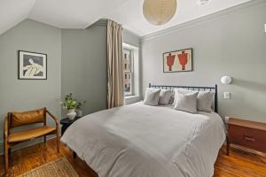 a bedroom with a large white bed and a chair at Suite 5B at Maison Dupont a Dupont Circle Inn in Washington, D.C.