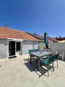 a patio with a table and chairs and an umbrella at Le Gustave - Proche ville in La Rochelle