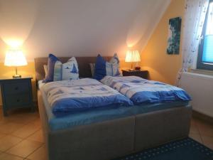a bedroom with a bed with blue sheets and pillows at Ferienhaus-Seehund in Glowe
