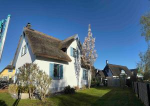 a white house with a thatched roof at Ferienhaus-Seehund in Glowe +18 photos