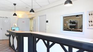 a counter in a room with a sign on the wall at Logis Hôtel & Restaurant Le Cheval Blanc et Clovis in Vouillé