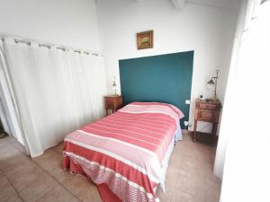 a bedroom with a bed with a striped blanket at Sur les dunes in La Guérinière