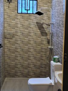 a bathroom with a toilet and a window and a sink at Matui House in Kinyasini