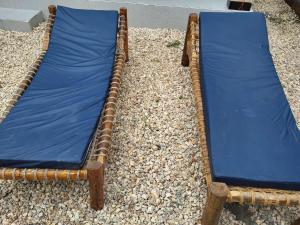 a wicker bed with a blue sheet on top of rocks at Matui House in Kinyasini