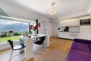 a kitchen and living room with a table and a purple couch at Il Roncaccio Residence Colico in Colico