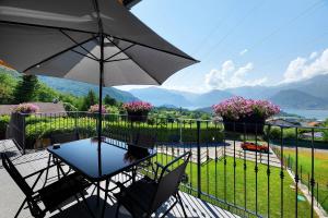 a table and chairs with an umbrella on a balcony at Il Roncaccio Residence Colico in Colico