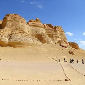 a group of people walking on the sand in the desert at Fayoum Safari Camp in Qaryat at Ta‘mīr as Siyāḩīyah