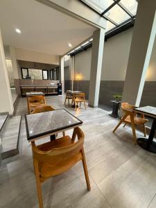 a room with tables and chairs and a piano at Wisma Pelangi 1 in Jakarta