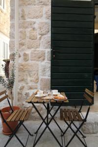 a table with food on it next to two chairs at Almara stone house - Authentic stone house in Vis in Vis +23 photos