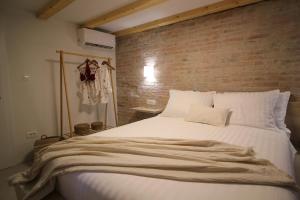 a bedroom with a large white bed with a brick wall at Almara stone house - Authentic stone house in Vis in Vis