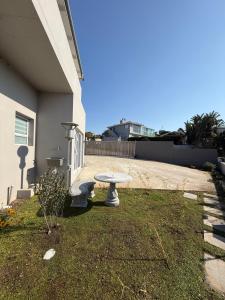 a picnic table in the grass next to a house at Berg & Baai guesthouse in Plettenberg Bay +15 photos