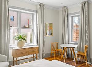a bedroom with a table and two windows at Suite 4C at Maison Dupont a Dupont Circle Inn in Washington, D.C.