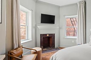 a bedroom with a fireplace and a tv on the wall at Suite 3B at Maison Dupont a Dupont Circle Inn in Washington, D.C.