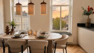 a dining room with a table and chairs and a window at Cooth's Prestige at the Square in Breda
