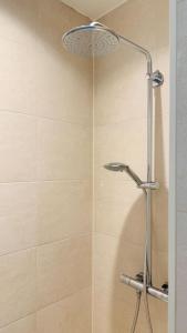 a shower with a shower head in a bathroom at Cooth's Prestige at the Square in Breda +12 photos