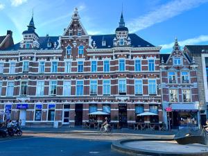 a large building with a person riding a bike in front of it at Cooth's Prestige at the Square in Breda
