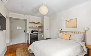 a bedroom with a white bed and a kitchen at Suite 5C at Maison Dupont a Dupont Circle Inn in Washington, D.C.