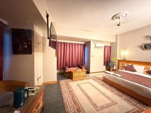 a bedroom with a bed and a living room at Hotel Pelri in Phuntsholing +7 photos