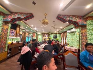 a group of people sitting at tables in a restaurant at Hotel Pelri in Phuntsholing