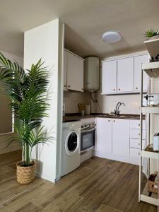 a kitchen with white cabinets and a washing machine at Max in Tossa de Mar