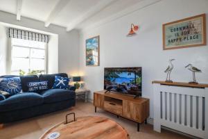 a living room with a couch and a tv at Stones Throw in St Austell