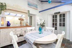 a white dining room with a table and chairs at Stones Throw in St Austell