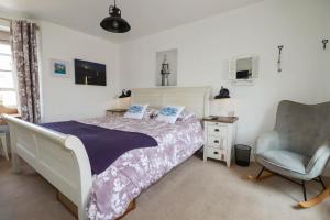 a bedroom with a bed and a chair at Stones Throw in St Austell