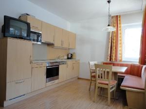 a kitchen with a table and chairs and a dining room at Apart Steffi in See