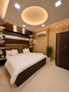 a bedroom with a large bed with a large ceiling at Megh hotel in Gangānagar