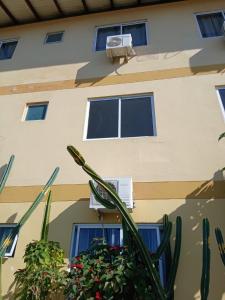 a building with windows and a plant in front of it at Hotel Norte Blu in Blumenau