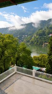 a balcony with a view of a river and mountains at The Oak Lake Cottage Boho in Nainital +21 photos