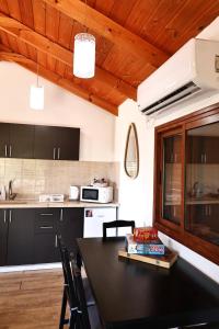 a kitchen with black cabinets and a black table at Orr Halevana in Bruchim Qela' Alon
