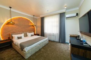 a hotel room with a large bed and a television at Istanbul Palace Hotel in Urganch