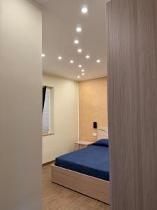 a bedroom with a bed with a blue bedspread at La Stella dei Venti in Scilla