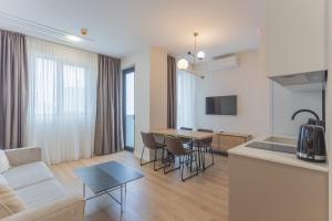 a kitchen and living room with a couch and a table at Nova Concierge Aparthotel in Batumi