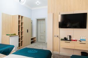 a bedroom with a bed and a television on a wall at Istanbul Palace Hotel in Urganch