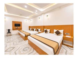a hotel room with two beds and a tv at निर्मला पैलेस अयोध्या राम मंदिर - Hotel The New Nirmala Palace Ayodhya Near-Ram-Janmabhoomi-and-Ayodhya-Ram-Mandir-with-parking-and-Restaurant-Facilities - Best Hotel In Ayodhya in Ayodhya