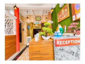 a restaurant with a reception counter with plants on it at निर्मला पैलेस अयोध्या राम मंदिर - Hotel The New Nirmala Palace Ayodhya Near-Ram-Janmabhoomi-and-Ayodhya-Ram-Mandir-with-parking-and-Restaurant-Facilities - Best Hotel In Ayodhya in Ayodhya