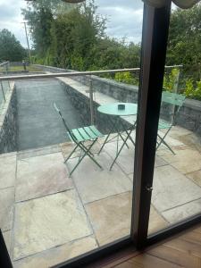a patio with a table and chairs on a balcony at The River Nook in Termonbarry