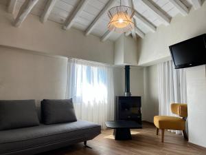 a living room with a couch and a fireplace at TERPOU StoneHouse & Suites in Volos +5 photos