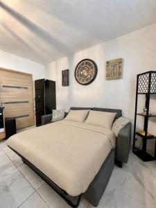 a bedroom with a large bed and a clock on the wall at Le Gustave - Proche ville in La Rochelle
