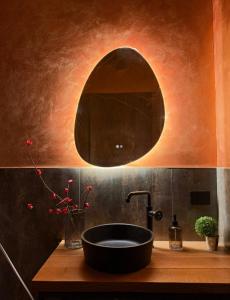 a bathroom with a bowl sink and a mirror at Stevoski Rooms - Modern Comfort in a Historic Stone House in Cormòns