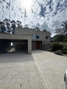 a house with a large driveway in front of it at Casa Benito - Barrio Privado con Piscina en Chapadmalal in Mar del Plata