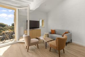 a living room with a couch and chairs and a television at apt hospital in Tourrettes-sur-Loup